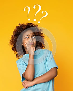 Child girl having questions over yellow background