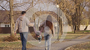 child girl with her father and mother return home, happy family, little kid dreams of flying, mom, dad and baby walk in