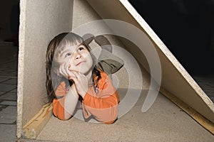 Child girl hiding in wooden box, dreams alone