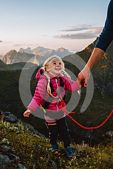 Child girl hiking with father holding hands in mountains of Norway adventure travel family vacations outdoor