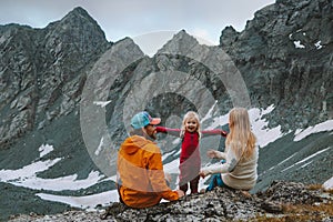 Child girl hiking with parents in mountains family travel summer vacations camping outdoor