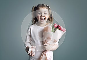 Child girl holding flowers bouquet and gift box loughing portrait. Spring promotional design card. Mother\'s da