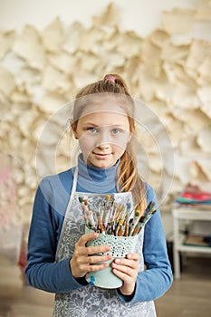 Child Girl Holding Paint Brushes in Art Studio