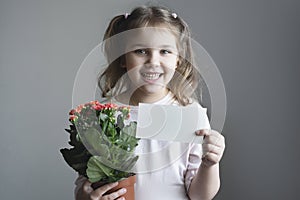 Child girl holding paper card portrait. Little kid with flower pot showing informatrion poster. Mother\'s day,holiday