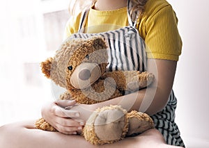 Child girl holding teddy bear. Plush toy closeup