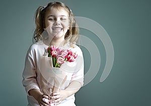 Child girl holiding tulips bouquet empty space background.Mother\'s day. Women\'s day. Spring time greeting card