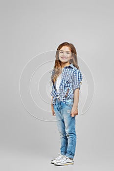 Child girl in jeans and plaid shirt