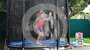 Child girl jumping on a trampoline and playing in a country house. Games for children.