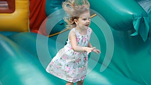 Child girl jumping on a trampoline and playing on playground for kids. Games for children.