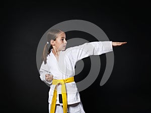 Child girl in karate suit with yellow belt show stance