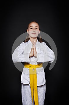 Child girl in karate suit with yellow belt show stance