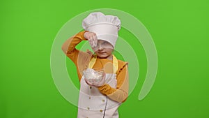 Child girl kid dressed in apron and hat like chef cook stir flour in plate on chroma key background