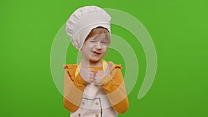 Child girl kid dressed as cook chef showing thumbs up, smiling, looking at camera on chroma key