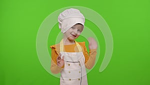 Child girl kid dressed as cook chef waving hands, asking to follow or join, welcome, hello gesture