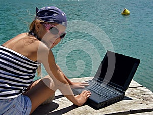 Child (girl) with laptop on sea