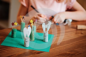 Child girl making easter craft tic tac toe game with bunnies and flowers