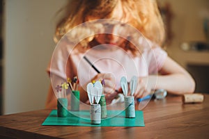 Child girl making easter craft tic tac toe game at home