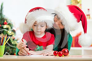 Child girl and mom writing christmas letter