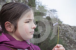 Child girl observing little wild flower