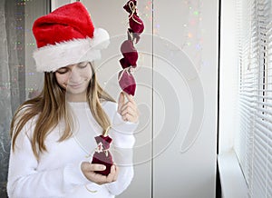 Child girl with long hair open small bags of gifts surprises advent calendar in her hands. Happy waiting of Christmas and New Year