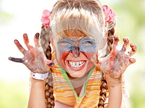 Child girl with paint on face.