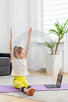 Child Girl Participates in Online Yoga Class at Home