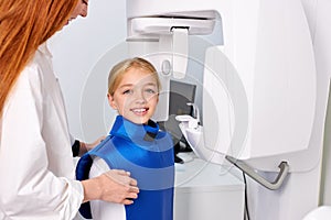 child girl patient doing panoramic teeth x-ray orthopantomography in clinic