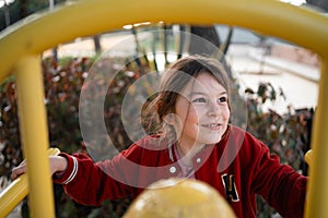 Child girl on the playground climbing structures, outdoors free play of primary school