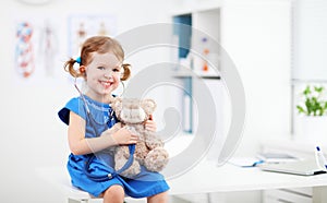 Child girl playing doctor with teddy bear