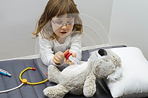Child girl playing doctor with a toy. Rescuing of endangered animals