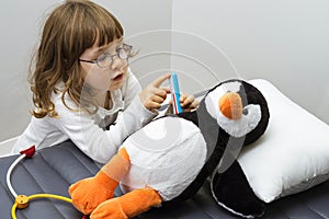 Child girl playing doctor with a toy. Rescuing of endangered animals