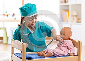 Child girl playing with doll in the hospital