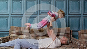 Child girl playing game laughing having fun with father, happy dad lifting small kid daughter up