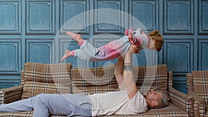 Child girl playing game laughing having fun with father, happy dad lifting small kid daughter up