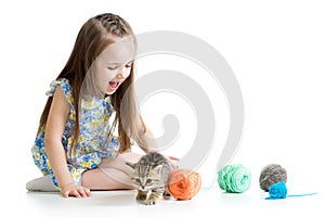 Child girl playing with kitten and balls