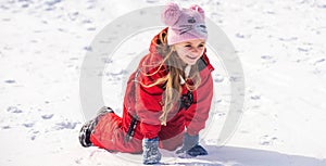 Child girl playing with snow in winter. Kids play in snowy park. Children catch snow flakes.