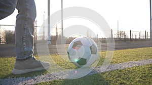 A child girl playing with soccer ball under sun light. Green field in city park at sunny day. Action sport outdoors of