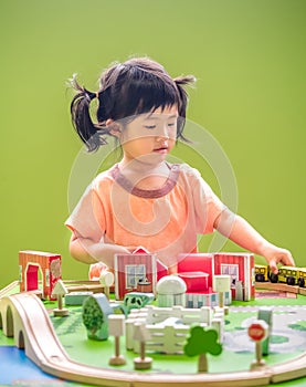 Child girl playing wooden train