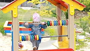Child girl plays in the playground in different games. Entertainment for children.