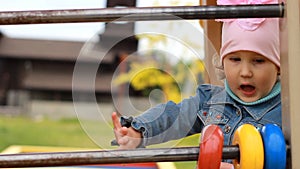 Child girl plays in the playground and learns to count in the game.