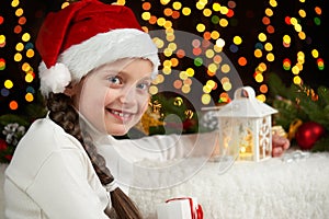 Child girl portrait with christmas decoration, dark background with lights, face expression and happy emotions, dressed in santa h