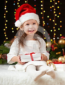 Child girl portrait in christmas decoration, happy emotions, winter holiday concept, dark background with illumination and boke li
