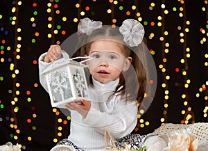 Child girl portrait in christmas decoration, happy emotions, winter holiday concept, dark background with illumination and boke li