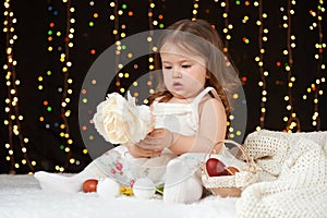 Child girl portrait in christmas decoration, happy emotions, winter holiday concept, dark background with illumination and boke li