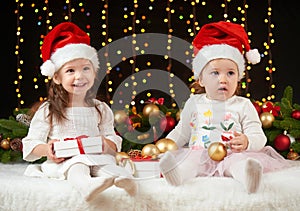 Child girl portrait in christmas decoration, happy emotions, winter holiday concept, dark background with illumination and boke li