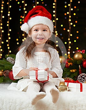 Child girl portrait in christmas decoration, happy emotions, winter holiday concept, dark background with illumination and boke li