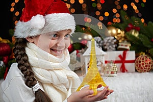 Child girl portrait with eiffel tower and christmas decoration, dark background with lights, face expression and happy emotions, d