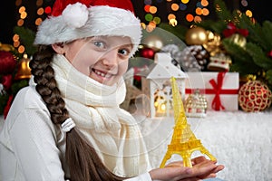 Child girl portrait with eiffel tower and christmas decoration, dark background with lights, face expression and happy emotions, d