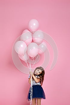 Child girl posing with pastel pink air balloons