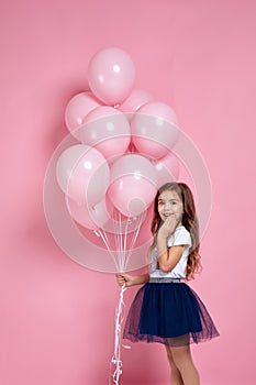 Child girl posing with pastel pink air balloons